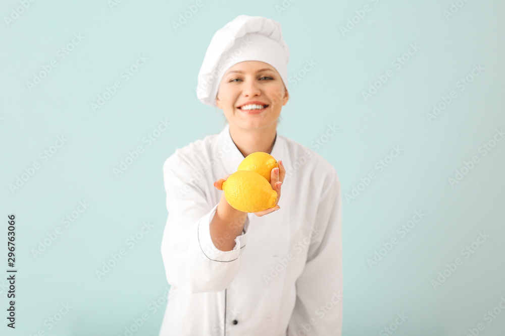 Beautiful female chef with lemons on light background Beautiful female chef with lemons on light background
