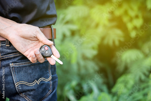 A man holding car key on nature background, journey of life concept