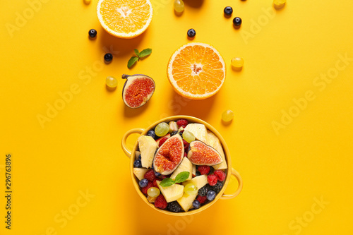 Εκτύπωση καμβά Pot with tasty fruit salad on color background