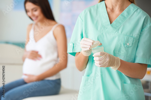 Gynecologist with container for urine sample in clinic, closeup