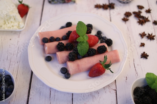Rolls of canned ham stuffed with cheese served with seasonal fruit. Tasty traditional food