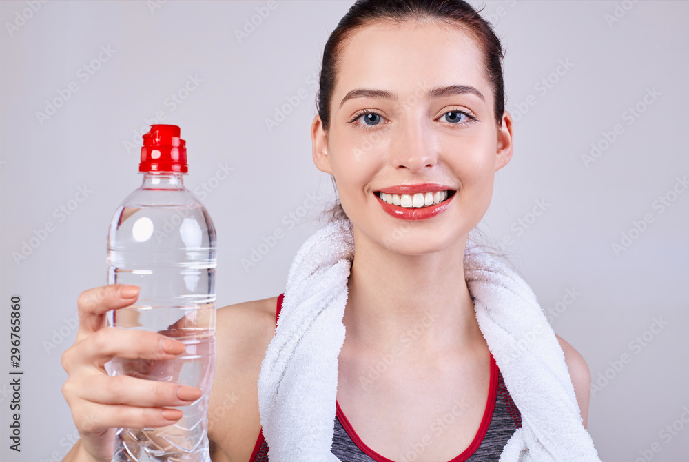 young beautiful girl brown hair with full lips with a bottle of water in her hand.