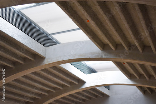 Modern white concrete arched ceiling with top windows and ventilation grilles.
