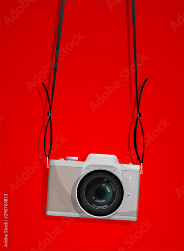 Compact photocamera with belt on the red background
