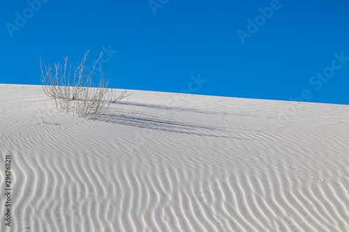 Ripples in the sand dunes at White Sands National Monument, New Mexico, with a clear blue sky overhead