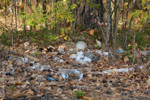 Garbage in forest. People illegally thrown garbage into forest. Concept of man and nature. Illegal garbage dump in nature. Dirty environment polluting Trash near hiking trail in forest. Trash