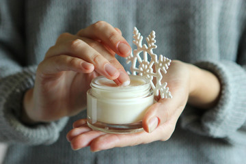 The girl uses cream. Winter hand skin care.