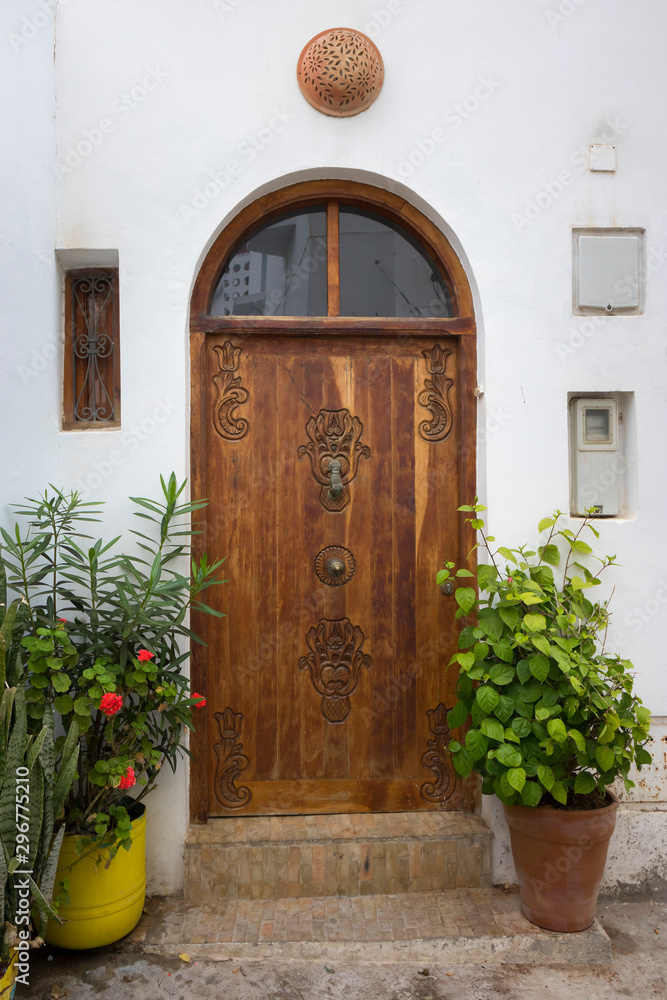 Old wooden door with knocker in the shape of a hand