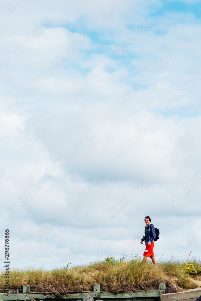 un homme marchant sur une plage. Un homme se promène vers une digue. un homme marchant sur une plage. Un homme se promène vers une digue.