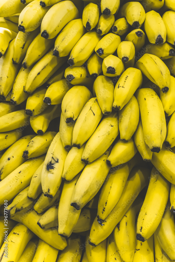 A bunch of bananas in the market. Many ripe yellow bananas on a supermarket counter