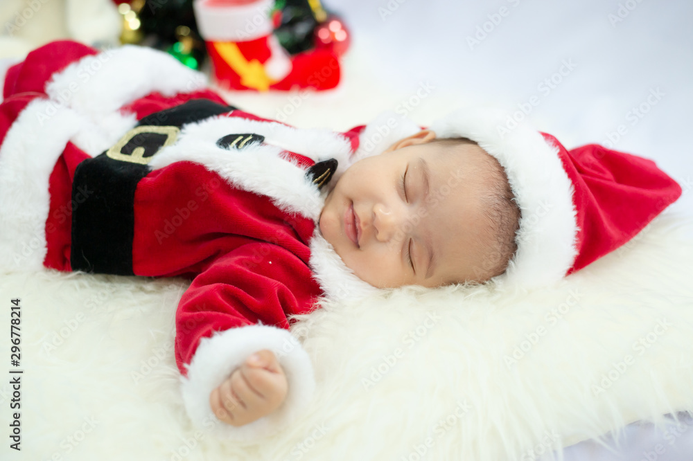 baby girl wearing red Santa Claus costume sleep on white fur carpet. Concept of celebrates Christmas and New Year's holidays. baby girl wearing red Santa Claus costume sleep on white fur carpet. Concept of celebrates Christmas and New Year's holidays.