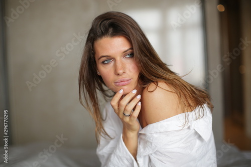 Seductive girl sitting on the bed in a thoughtful pose.