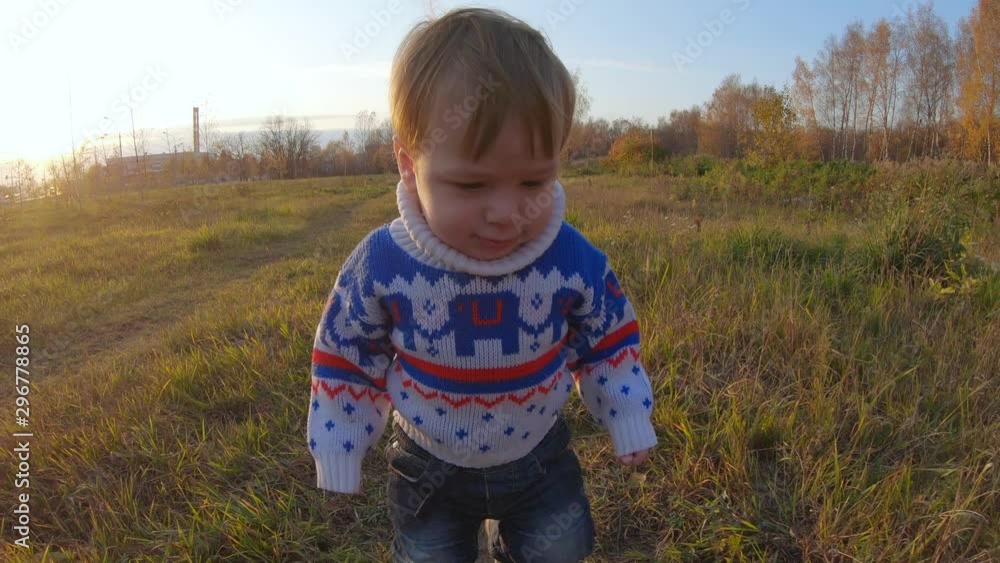 Infant boy walking and falling grass Infant boy walking and falling grass