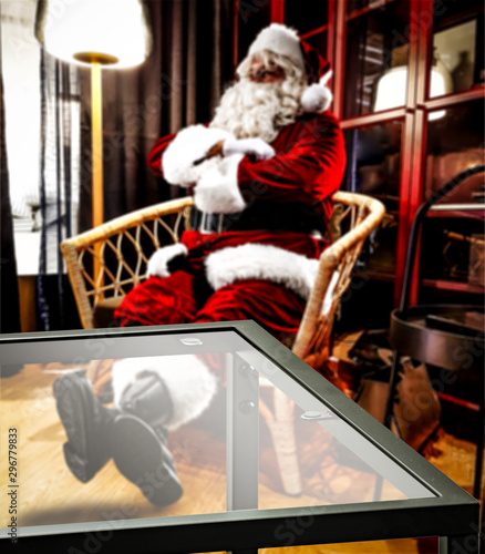 Glass coffee table of free space for your decoration and red old Santa Claus in home interior 