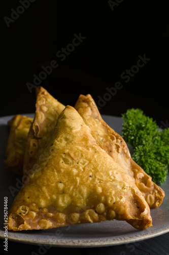 Samosas a spicy blend of vegetables or meat wrapped in a deep fried triangular pastry parcel a popular snack in the Middle East and South Asia photo