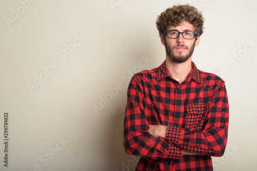 Young bearded hipster man wearing eyeglasses with arms crossed