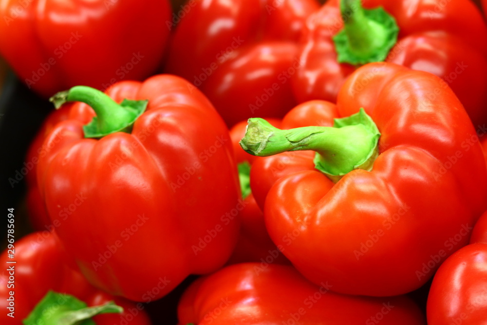 Red bell peppers on a counter in the supermarket. A large number of red peppers in a pile - Red bell peppers on a counter in the supermarket. A large number of red peppers in a pile -