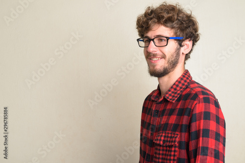 Closeup profile view of happy young bearded hipster man with curly hair smiling © Ranta Images