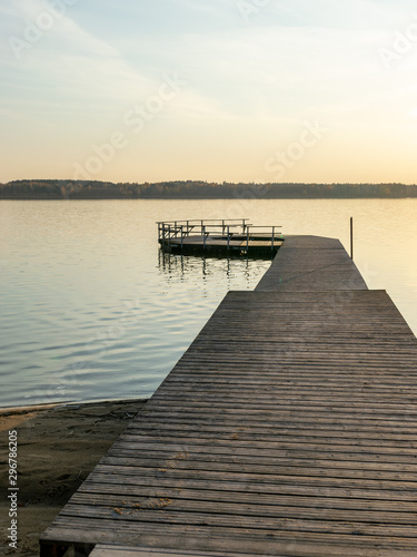 Fototapeta Naklejka Na Ścianę i Meble -  picture with a wooden footbridge on the lake in sunset light