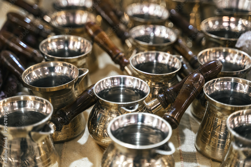 Turkish copper coffee pots with ornaments on a counter in a Turkish bazaar Turkish copper coffee pots with ornaments on a counter in a Turkish bazaar