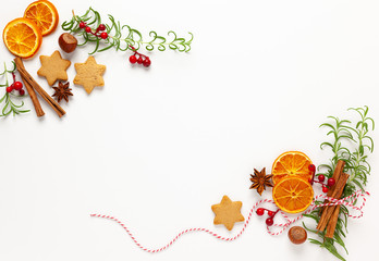  Christmas composition with cookies, dried oranges, cinnamon sticks and herbs on white background. Natural food ingredient for cooking or Christmas decor for home. Flat lay.