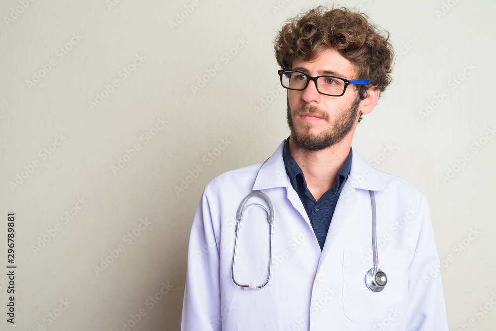 Face of young bearded man doctor with eyeglasses thinking Face of young bearded man doctor with eyeglasses thinking