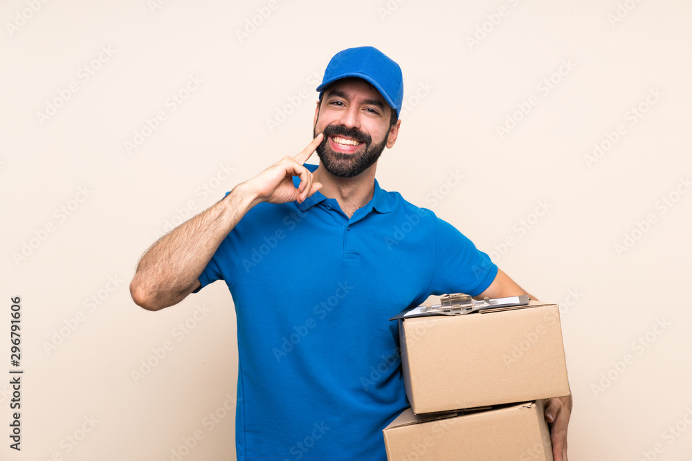 Delivery man with beard over isolated background smiling with a happy and pleasant expression