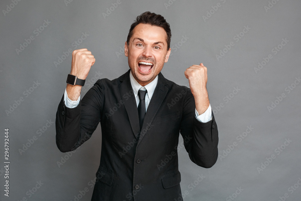 Businessman studio standing isolated on grey hands up shouting successful Businessman studio standing isolated on grey hands up shouting successful