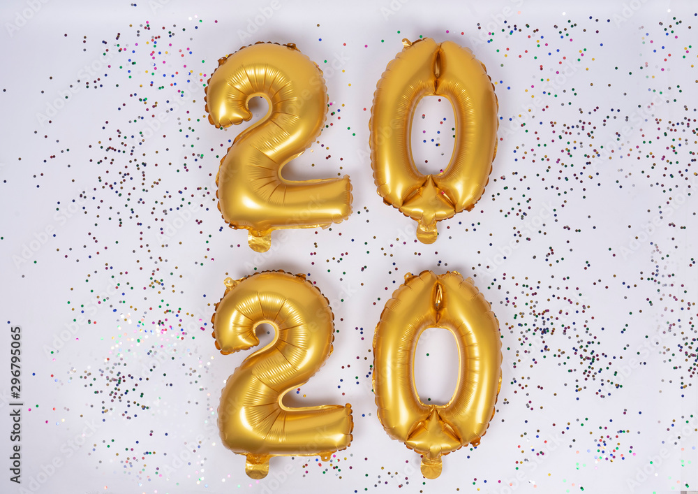 2020 number of frustrated gold balloons isolated with colored confetti on white background. Happy new year 2020 holiday. 2020 number of frustrated gold balloons isolated with colored confetti on white background. Happy new year 2020 holiday.