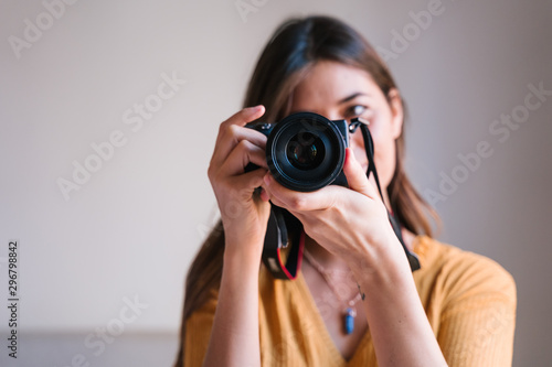 photographer woman at home holding a camera. Technology and lifestyle indoors