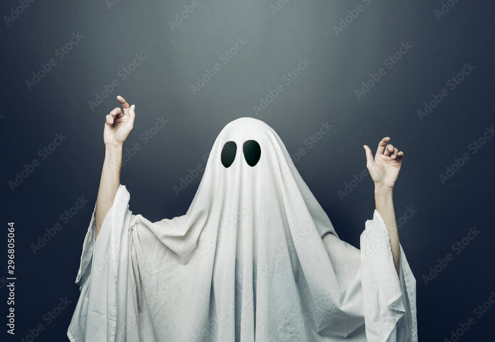 Girl in costume Spooky white ghost with black eyes on a gray background. Halloween minimal concept Girl in costume Spooky white ghost with black eyes on a gray background. Halloween minimal concept