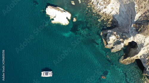 Aerial drone photo of iconic famous White beach with deep rocky and volcanic turquoise sea visited by sail boats, Santorini island, Cyclades, Greece