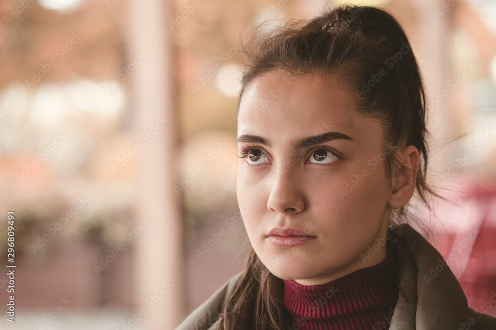 Brunette girl in a sweater in a cafe on the street in the autumn in a pensive mood. Brunette girl in a sweater in a cafe on the street in the autumn in a pensive mood.