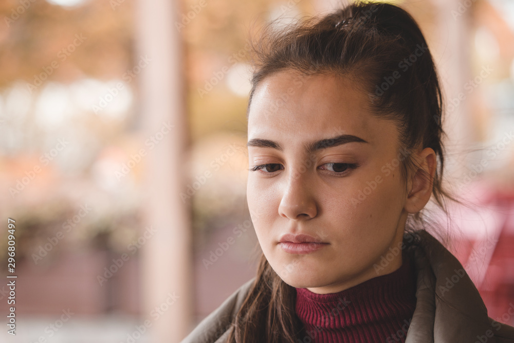 Brunette girl in a sweater in a cafe on the street in the autumn in a pensive mood. Brunette girl in a sweater in a cafe on the street in the autumn in a pensive mood.