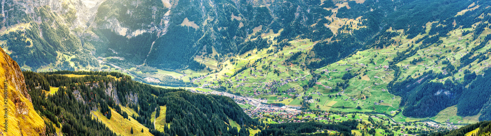 Banner of Grindelwald village in Switzerland, view from above. Panoramic landscape of small Swiss village, green valley.