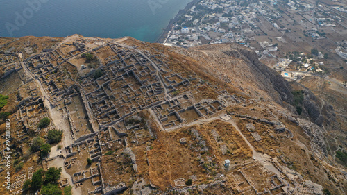 Aerial drone photo of iconic archaeological site of ancient Thera or Thira built uphill with amazing views to Kamari and Perissa beaches and seaside villages, Santorini island, Cyclades, Greece photo