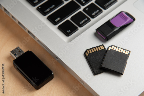 Memory Cards, Flash Drive, Card Reader, Laptop computer on wooden background