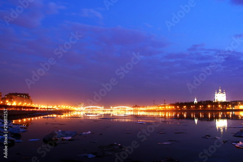 ice floes float on the night river embankment of the city with illumination photo