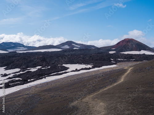 Red and black volcanic Iceland landscape at Fimmvorduhals hiking trail with glacier volcano lava field, snow and magni and mudi hill, createed by eruption of Eyjafjallajokull in 2010 which affected