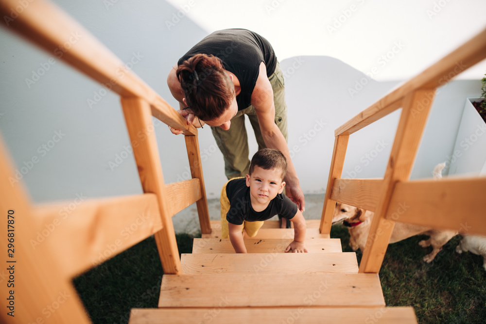 Toddler boy crawling up the stairs at tree house Toddler boy crawling up the stairs at tree house