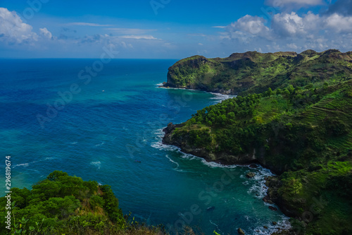 View of landscape ocean and nice green hill on white clouds and Blue sky background. Kebumen, Central Java, Indonesia