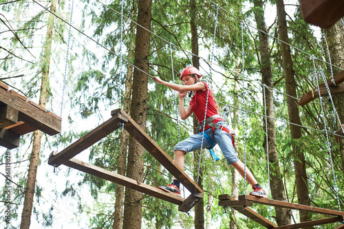 Girl at climbing activity in high wire forest park