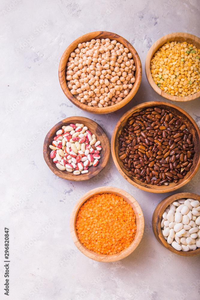 Legumes, lentils, chikpea and beans assortment in different bowls on white table top view. Legumes, lentils, chikpea and beans assortment in different bowls on white table top view.