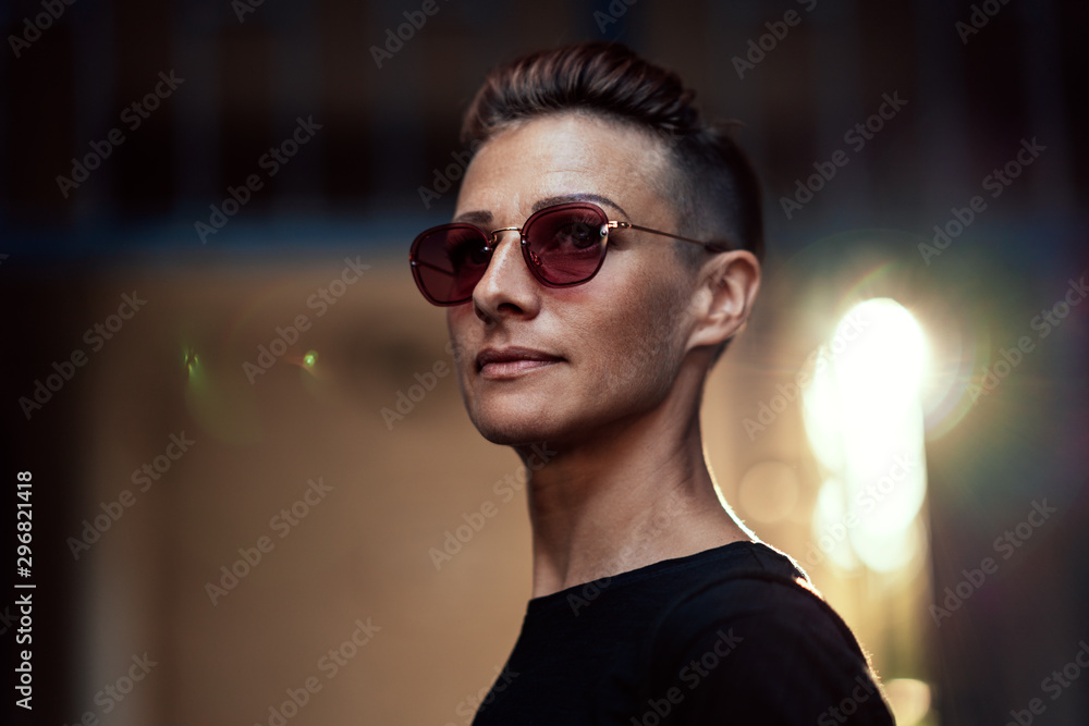 Portrait of woman with mohawk hairstyle standing in front of the building entrance Portrait of woman with mohawk hairstyle standing in front of the building entrance