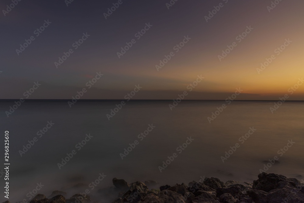Gorgeous colorful view of sunset on Aruba. Beautiful nature landscape. Rocky coast of Atlanta, Caribbean.