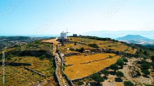 Aerial view of amaizng landscape with mountains and windmill under blue sky photo