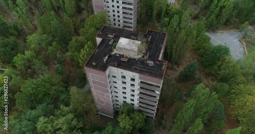 Flying a drone over Pripyat around a tall house, rotating clockwise old part city
