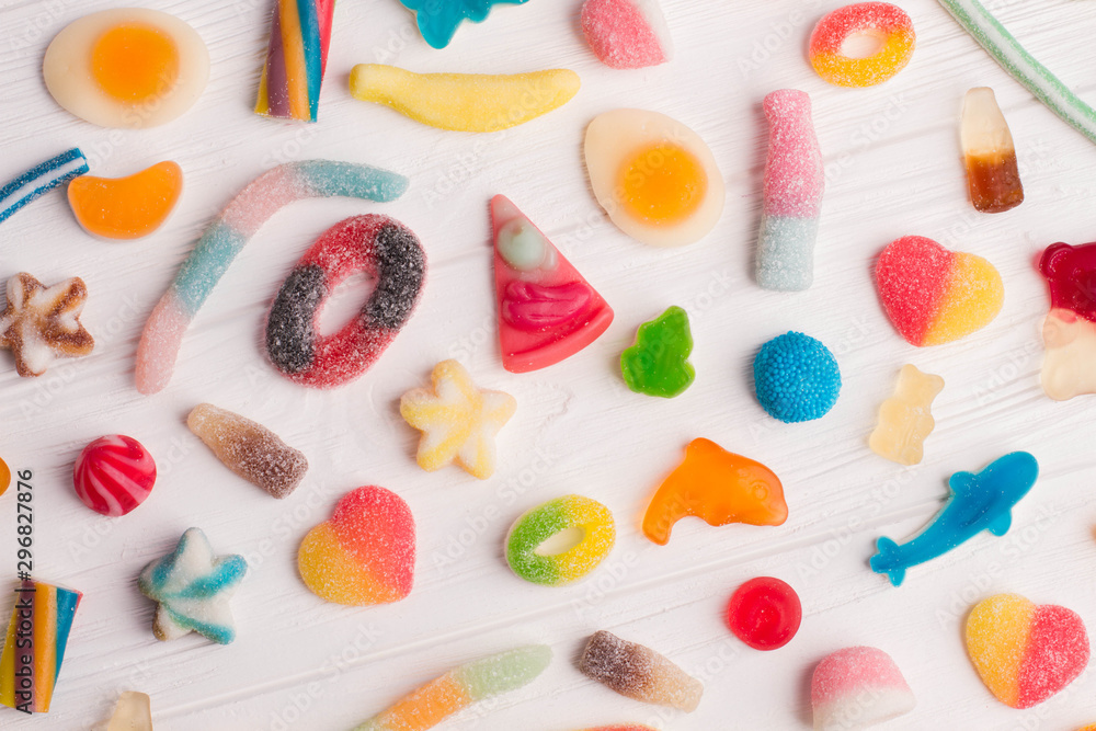 Background of colorful candies. Many different candies on white wooden background.