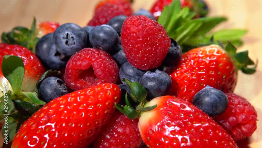 Top view of amount of fresh forest berries rotating on plate. Ripe strawberries, blackberries and raspberries. Variety of nutritional properties for human body. Healthy eating, berries mix for making Top view of amount of fresh forest berries rotating on plate. Ripe strawberries, blackberries and raspberries. Variety of nutritional properties for human body. Healthy eating, berries mix for making