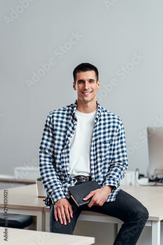 Businessman sitting on the desk and holding note pad at the office